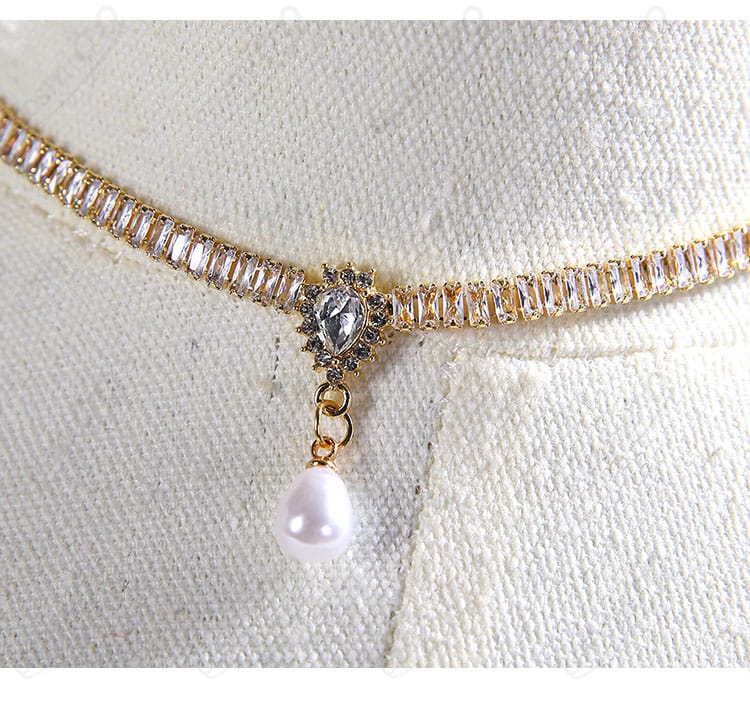 ネックレスと首元のディテール。パール調の質感と留め具の仕上げが分かるアップ。